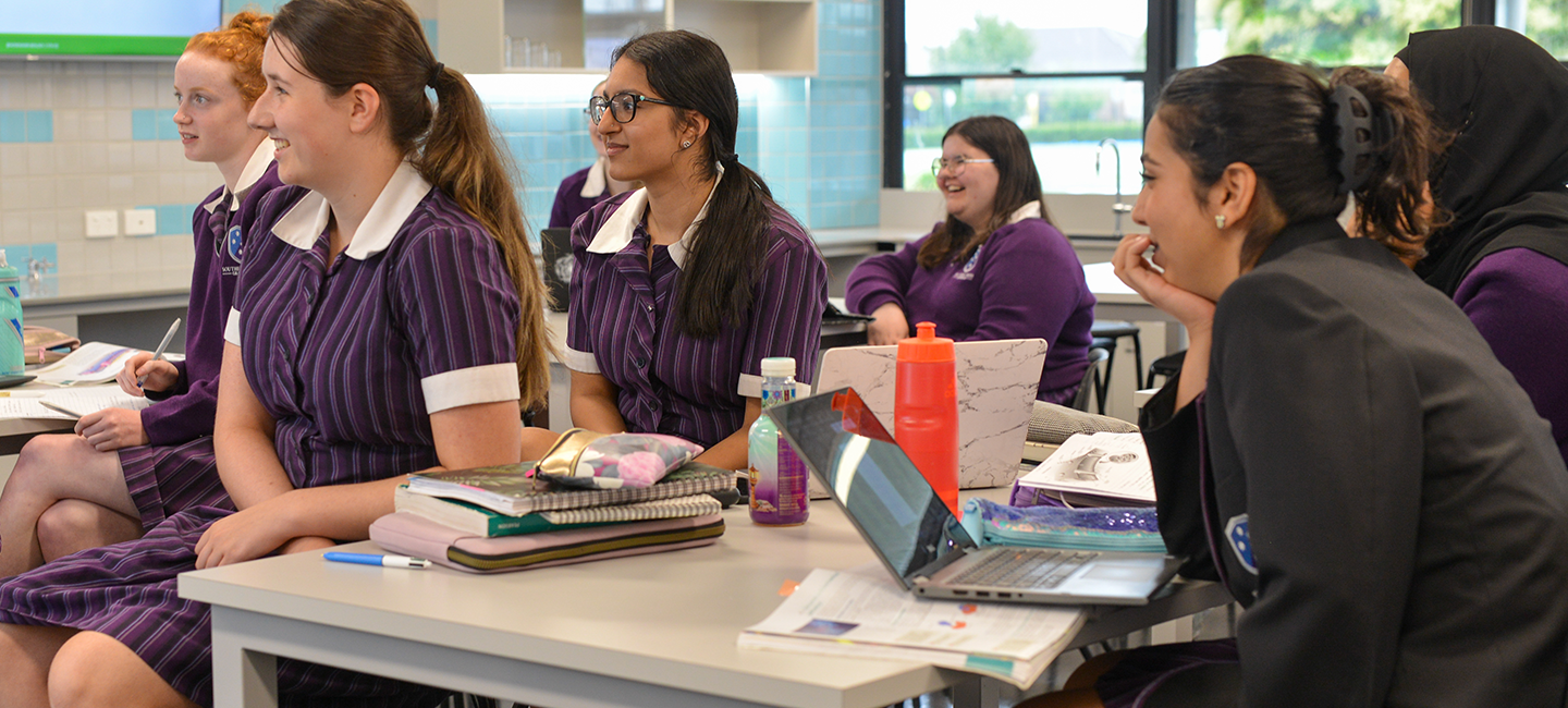 Six female Southern Cross Grammar students listening to their teacher in the upgraded STEM lab.
